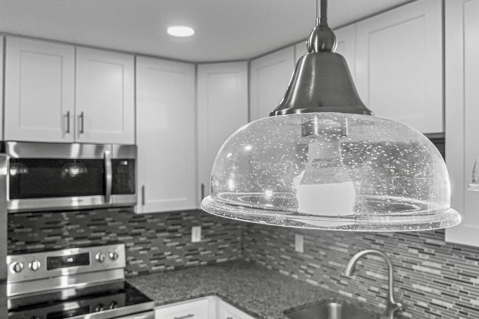 Bubble glass pendant light over kitchen counter — The Bayfront Residence, Palm Coast, FL