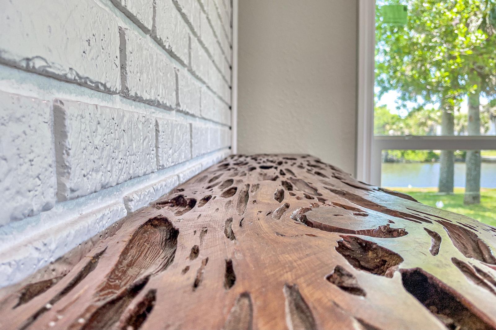 Live-edge wood console against white brick wall with canal view — Canal Vista Residence, Palm Coast, FL