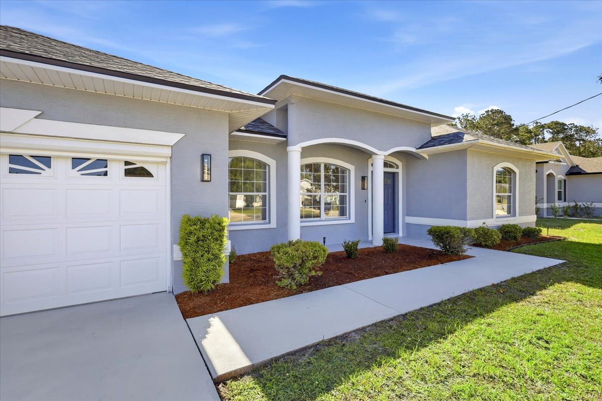 Curb appeal — driveway and front facade of The Royal Palms House, Palm Coast, FL