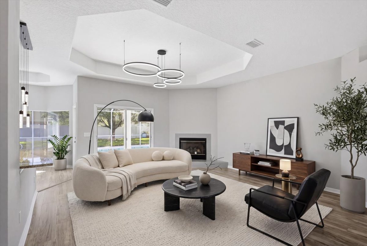 Open living room with curved sofa and tray ceiling — The Royal Palms House